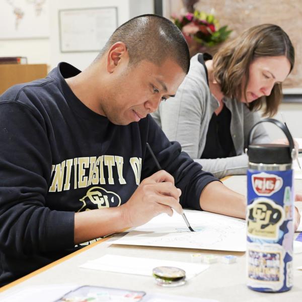 Two people make art at a table