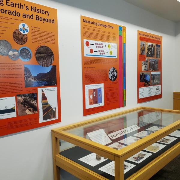 Two panels from the exhibit and a display case with information and rocks 