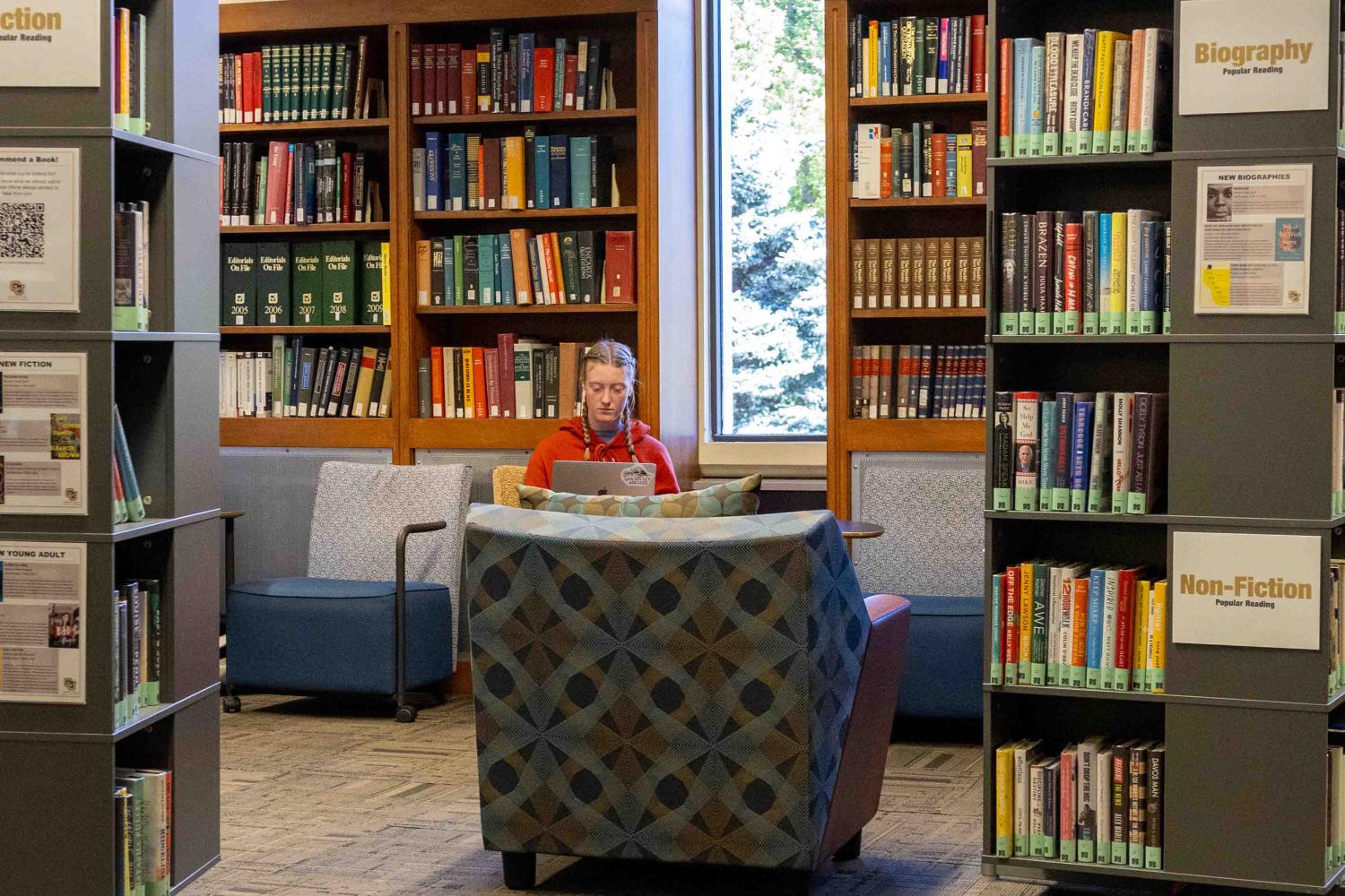 A student reads in the popular reading collection