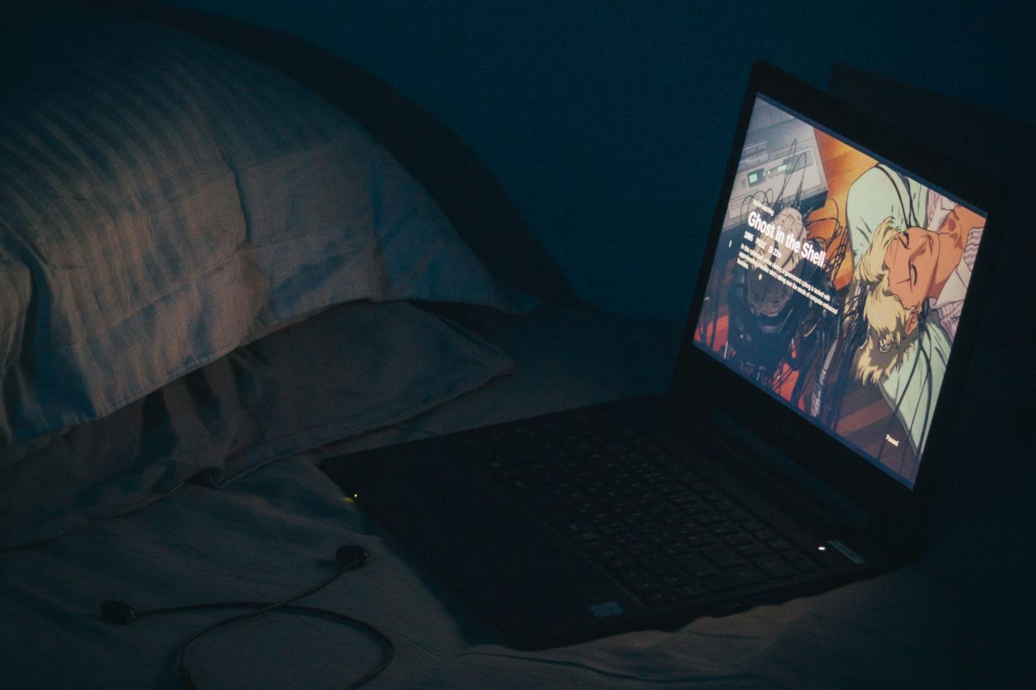 Open laptop playing a movie in bed