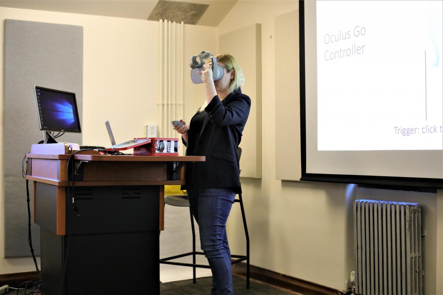 Fellow Julia demonstrates how to use VR goggles during her presentation.