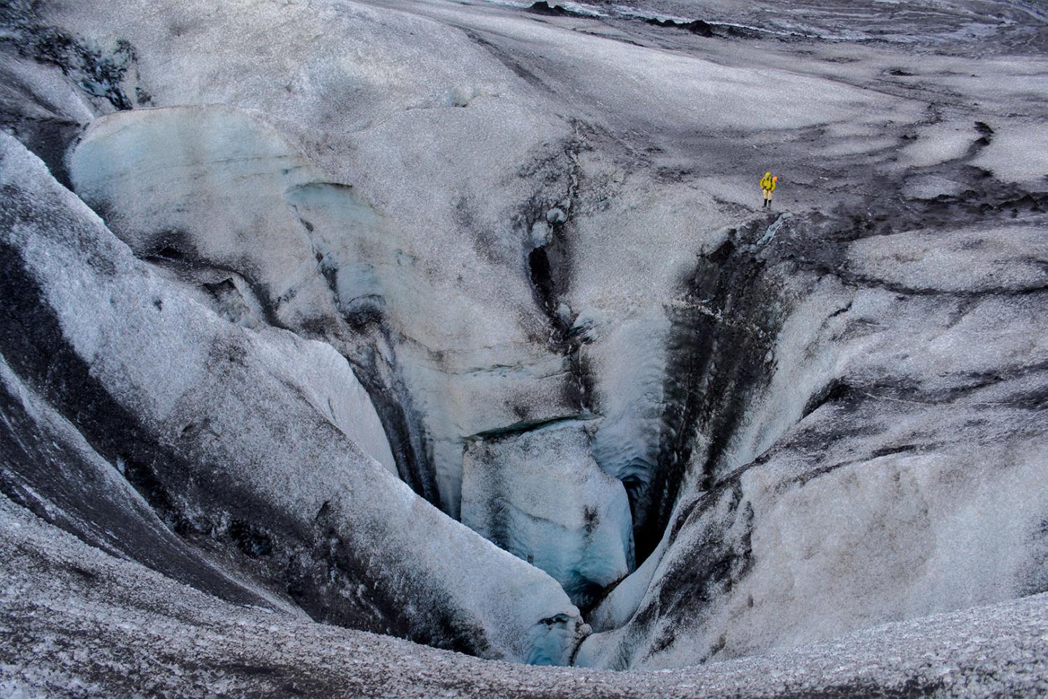 A man standing on a glacier in the arctic.