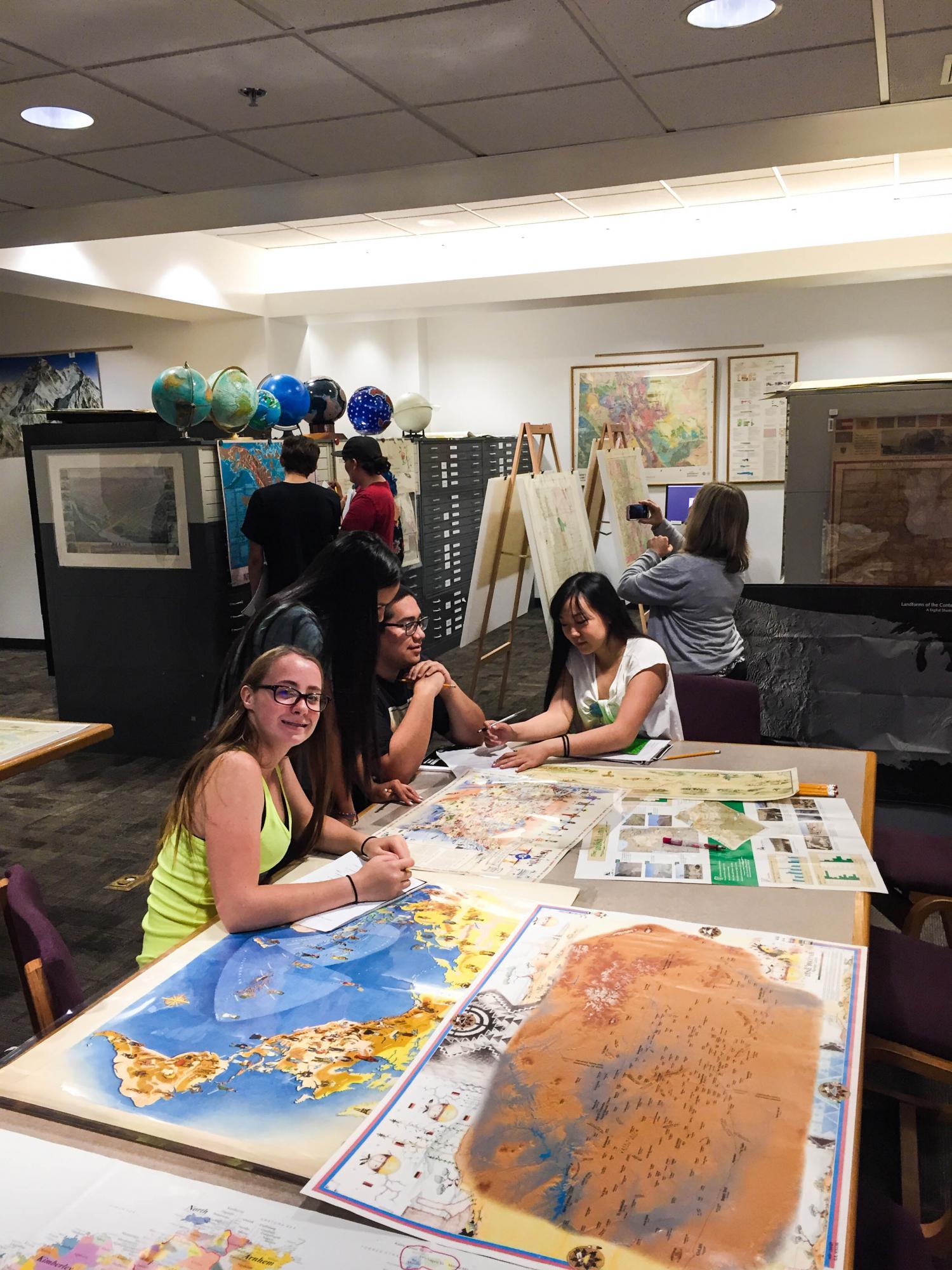 Students from Boulder Prep looking at maps and government documents in the Earth Sciences and Map Library.