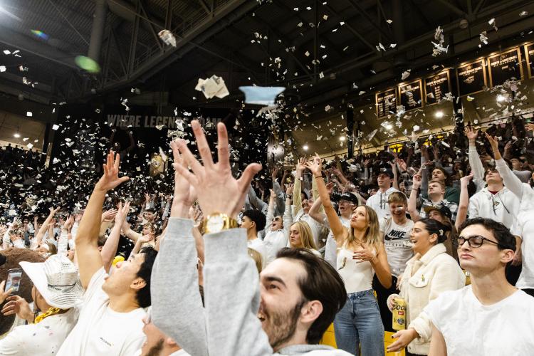 CU basketball fans toss shredded newspaper into the air at a game