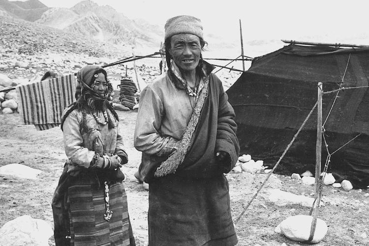 Man and woman pastoralists standing in front of camp
