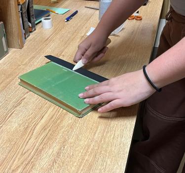 The Libraries Preservation and Collection Care team works to repair a book.