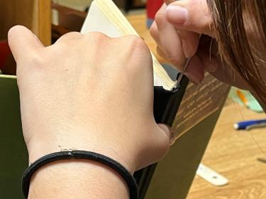 The Libraries Preservation and Collection Care team works to repair a book.